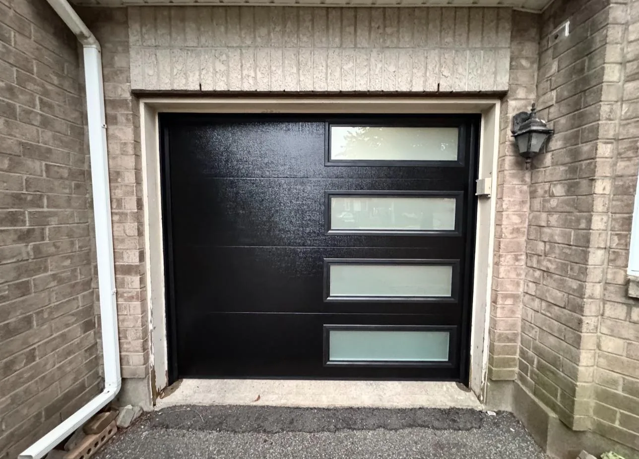 New black modern garage door with frosted windows installed by Safe and Sound Garage Doors in Ottawa